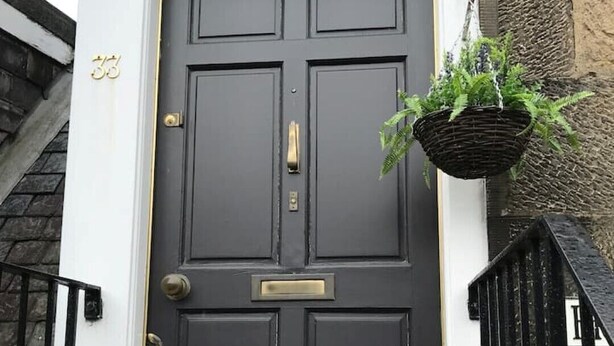 A black front door with a gold handle and a small mailbox above it. - STYLISH APARTMENT WITH PRIVATE ROOF TERRACE (Edinburgh)