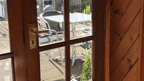 A wooden door with a view of an outdoor patio area. - STYLISH APARTMENT WITH PRIVATE ROOF TERRACE (Edinburgh)