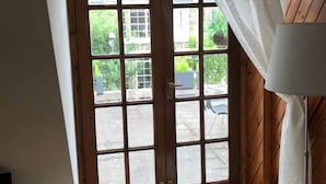 A wooden-framed door with a window, a small bench, and a lamp. - STYLISH APARTMENT WITH PRIVATE ROOF TERRACE (Edinburgh)