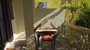 Un espace extérieur aménagé avec une table et des chaises, un banc et une nappe décorative.