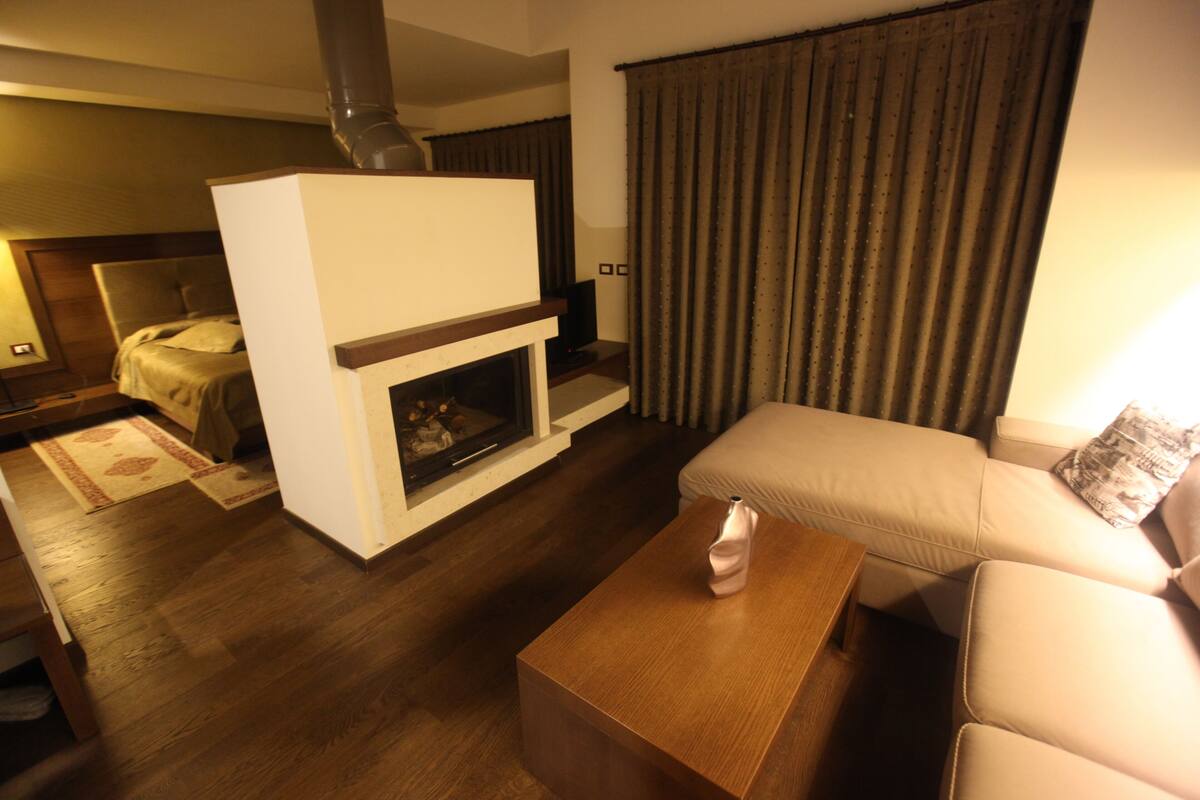 A modern living room with a fireplace, a sofa, and a wooden coffee table.