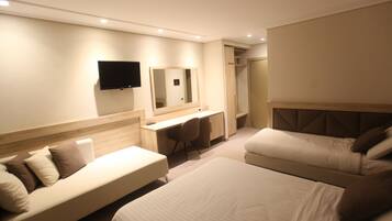 Ein modernes Hotelzimmer mit Bett, Sofa, Schreibtisch und Fernseher.