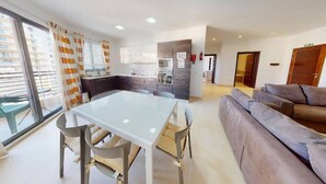 A modern apartment with a dining area, kitchen, and living room. - Modern 5th floor 2 bedroom apartment in Tigne (Sliema)