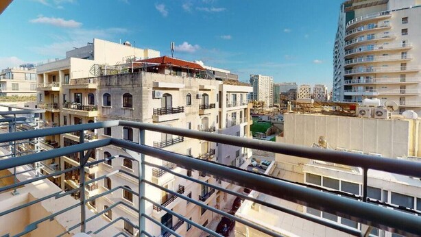 A multi-story building with balconies and a clear blue sky. - Modern 5th floor 2 bedroom apartment in Tigne (Sliema)