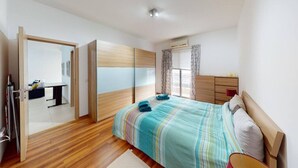 Ein Schlafzimmer mit einem Bett, einem Schreibtisch und einem Kleiderschrank.