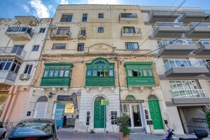A multi-story building with green-framed windows, a visible entrance, and a sign for 'Golden Barber VIP'. - the Queen Freddy Penthouse (Ta` Xbiex)