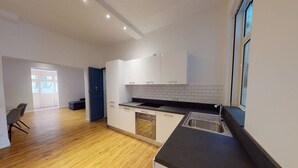 Una cocina moderna con armarios blancos, encimera negra y una ventana.