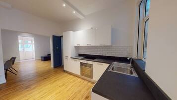 A modern kitchen with white cabinets, a black countertop, and a window.