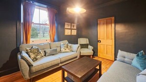 Una sala de estar acogedora con sofá, sillón y una mesa de centro.