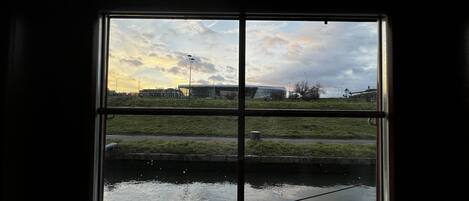 A window with a view of a building and a grassy area.