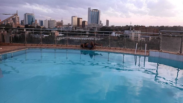 A rooftop swimming pool with a city skyline in the background. - Lux Suites kipande Road Studio Apartment (Nairobi)