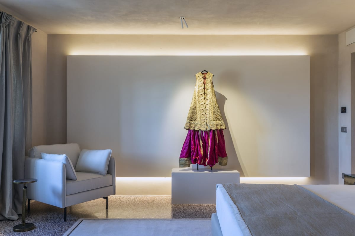 A modern room with a sofa, a small table, and a decorative item on a pedestal.