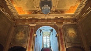 A grand staircase with a red carpet, leading to a balcony with a view. - Palazzo Durazzo Suites (Genoa)