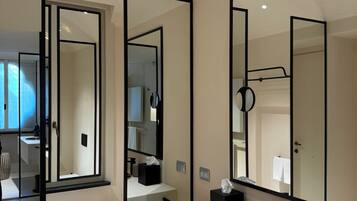 A modern bathroom with a white sink, a round mirror, and a toilet.