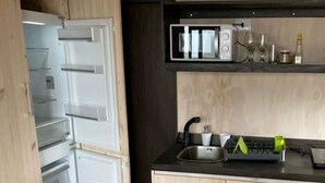A compact kitchen with a microwave, sink, and storage drawers. - Vista Mar Pupuya Matanzas Cabaña 2 (O'Higgins)