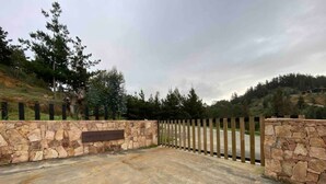 A gated driveway leading to a stone wall with a sign. - Vista Mar Pupuya Matanzas Cabaña 2 (O'Higgins)