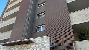 Un bâtiment moderne avec une façade en pierre et une enseigne indiquant « POETTO 108 ».