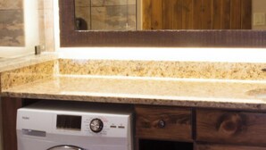 A kitchen with a granite countertop, wooden cabinets, and a built-in washing machine. - Westgate Resort with beautiful mountain views, Smoky Mountain National Park (Gatlinburg)