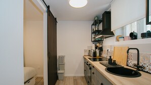 A compact kitchen with a wooden countertop, a black sink, and a built-in stove. - First love Apartment in Zagreb center (Zagreb)