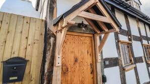 A traditional half-timbered house with a wooden door, a mailbox, and a number plaque. - 18 Church Street (Llangollen)