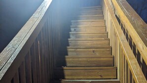 Eine Holztreppe mit Handlauf, die nach oben führt.