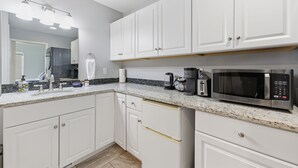 A modern kitchen with white cabinets, a stainless steel microwave, and a coffee maker. - Cozy Queen, Private Bathroom and Entryway (Bend)