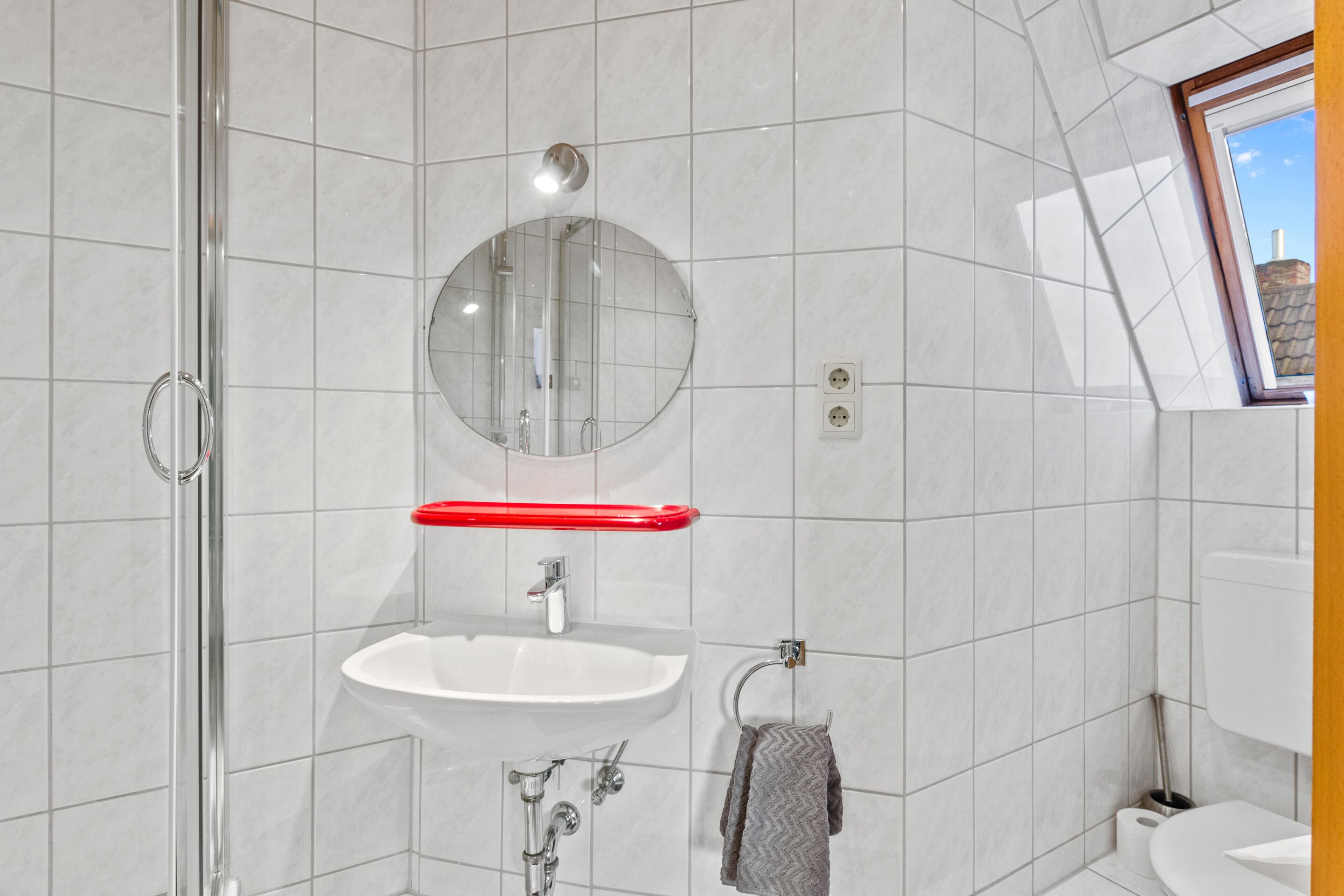 Et moderne badeværelse med bruser, vask og toilet.