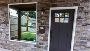 A house entrance with a dark front door, a mailbox, and a window with a view of the street. - Chic & Cozy Home Near UK Campus! Perfect for Family Visits. (Lexington)