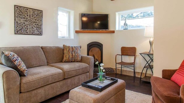 Una sala de estar con un sofá, una mesa de centro, un televisor y una chimenea.