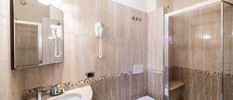 A modern bathroom with a vanity, bidet, toilet, and a glass-enclosed shower area.