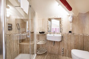 Un baño moderno con ducha de vidrio, lavamanos blanco y un inodoro.