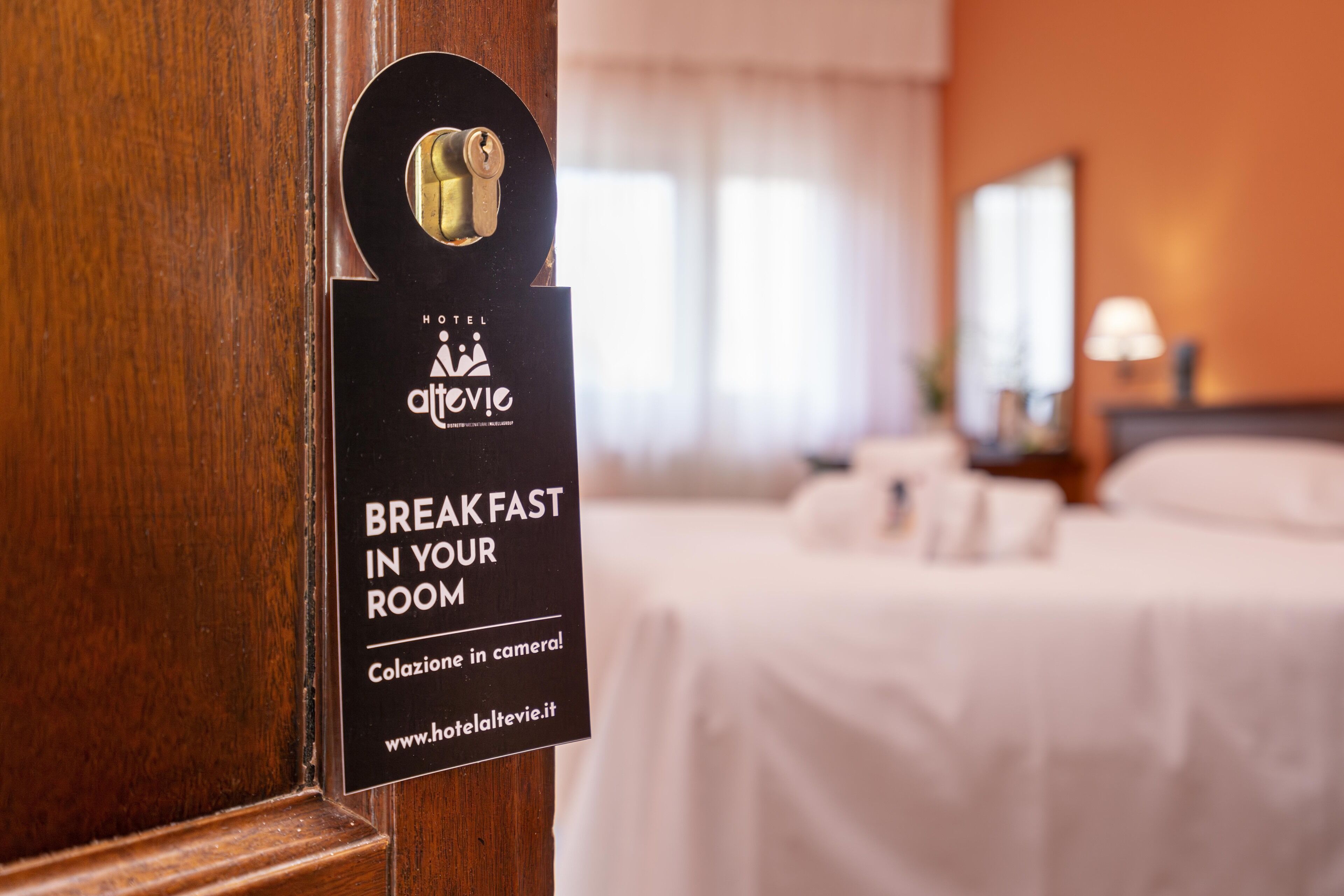 A hotel room door with a sign indicating breakfast is available in the room.