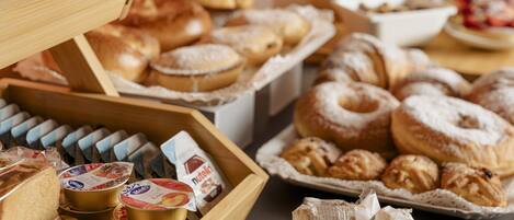 A variety of pastries and bread displayed on a table.