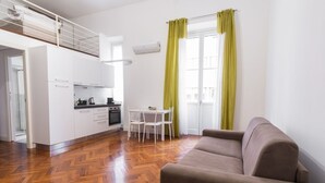 Un espai vital compacte amb cuineta, zona de menjador i sofà.