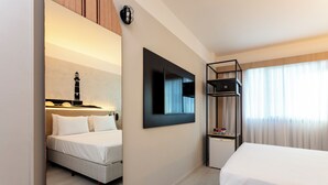 Een hotelkamer met een bed, een bureau, een spiegel, een televisie en een plank.