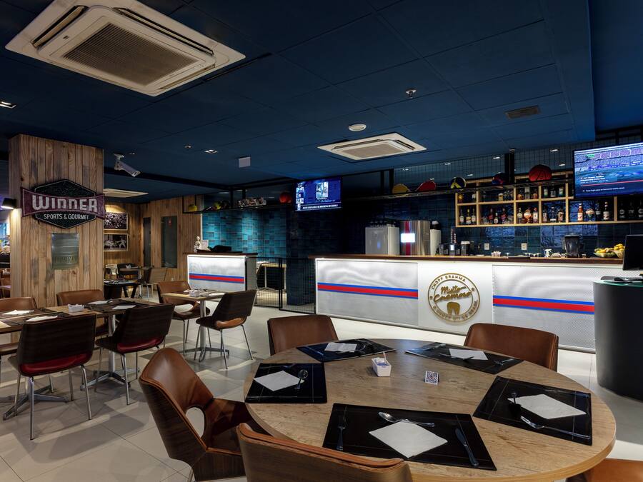 Ein Restaurant mit Barbereich, Holzeinrichtung und sportlichem sowie Gourmet-Ambiente.