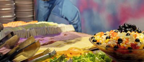 Ein Buffet mit ausgewiesenen Bereichen für verschiedene Speisen, darunter eine Schüssel Mais und ein Salat.