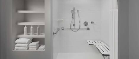 Un baño moderno con ducha, inodoro y un estante con artículos de aseo.
