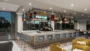 Uma área de bar moderna com um balcão comprido, vários bancos e uma variedade de garrafas.