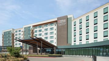 Welcome to the Hilton Garden Inn, featuring a modern entrance with a metal canopy and glass and brick facade.