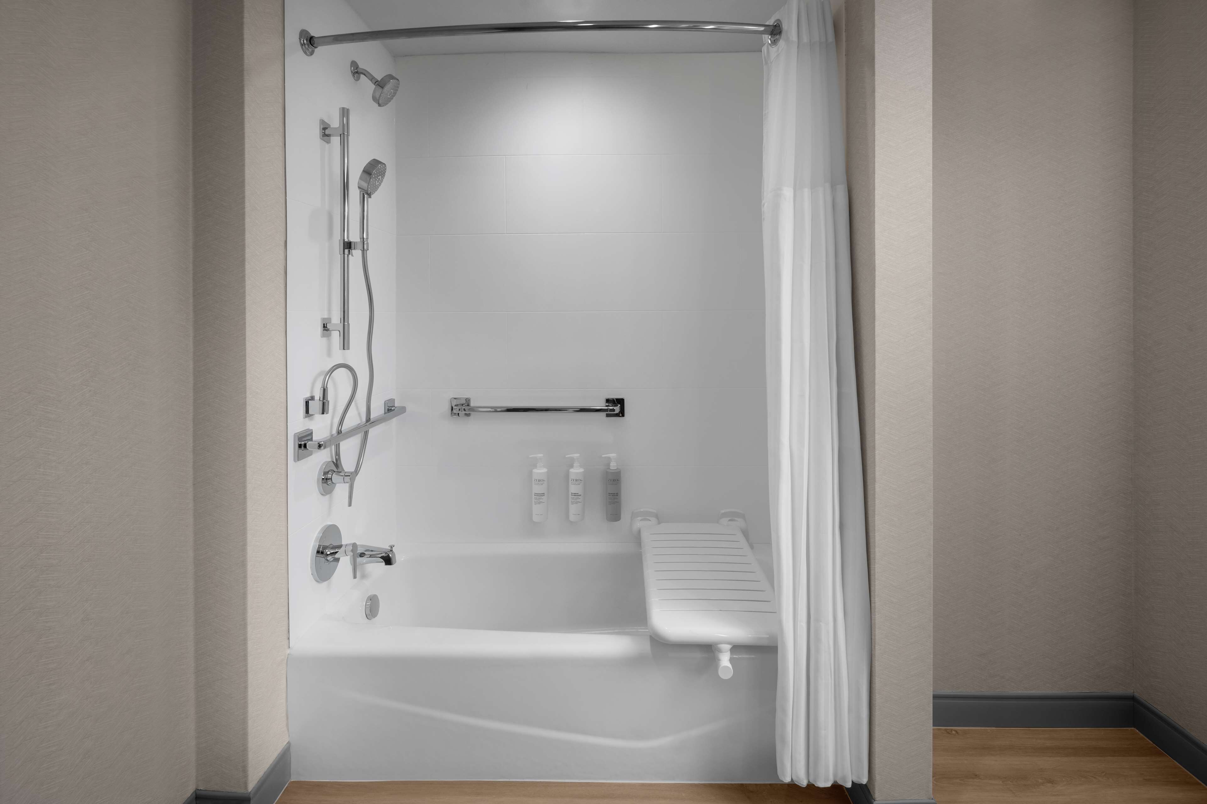 Een moderne badkamer met een bad, douche en toilet.