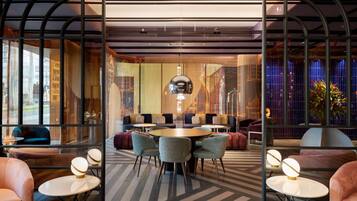 A modern lounge area with a round table, comfortable seating, and ambient lighting.