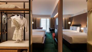 A hotel room with two beds, a desk, a chair, a robe, slippers, and a hairdryer.
