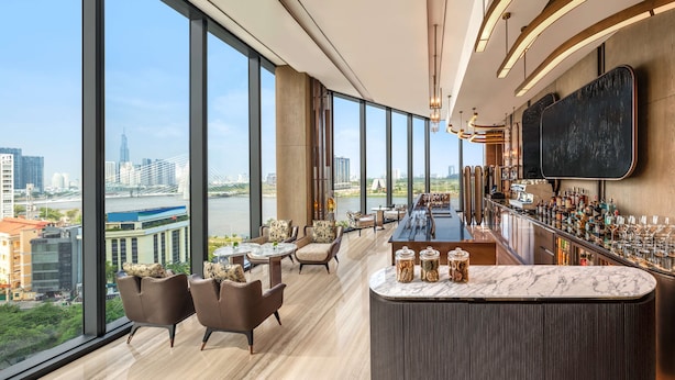 A high-rise bar with a city view, large windows, and modern furnishings. - Hilton Saigon (Ho Chi Minh City)