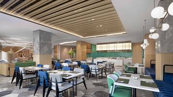 Un restaurante moderno con varias áreas de comedor, un bar y una cocina visible al fondo.