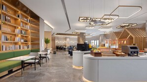 A modern library with bookshelves, seating areas, and a food service counter. - Hilton Garden Inn Zigong High-Tech Zone (Zigong)