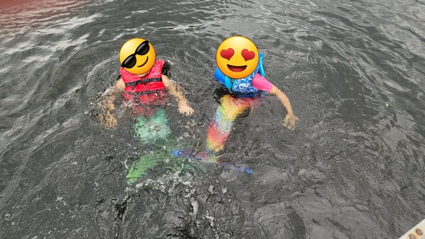 Two people in a swimming pool with water splashing around them.