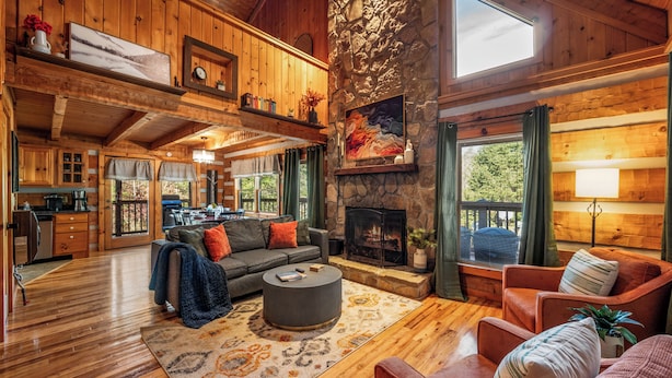 A spacious living room with a fireplace, wooden floors, and a cozy seating area. - Epic Retreat I Pickleball I Basketball I Arcade I Putting Green I Air Hockey (Sevierville)