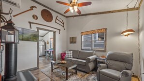 A living room with a fireplace, a sofa, a recliner, and a coffee table. - Lumberjack Family Retreat I Putt Putt I Pool Table I Darts I Hot Tub I Firepit (Sevierville)