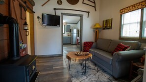 A cozy living room with a fireplace, a sofa, and a television. - Lumberjack Family Retreat I Putt Putt I Pool Table I Darts I Hot Tub I Firepit (Sevierville)